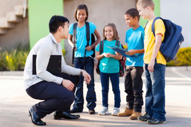 Elementary pupils outside classroom talking to teacher. Courtesy: nspt4kids.com